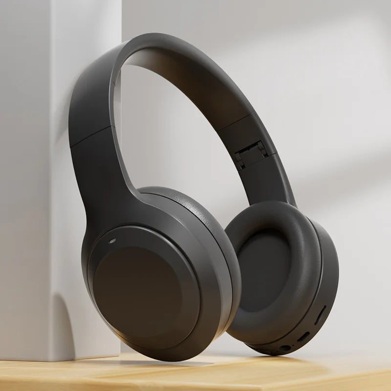 Black headphones on a wooden surface with a white background