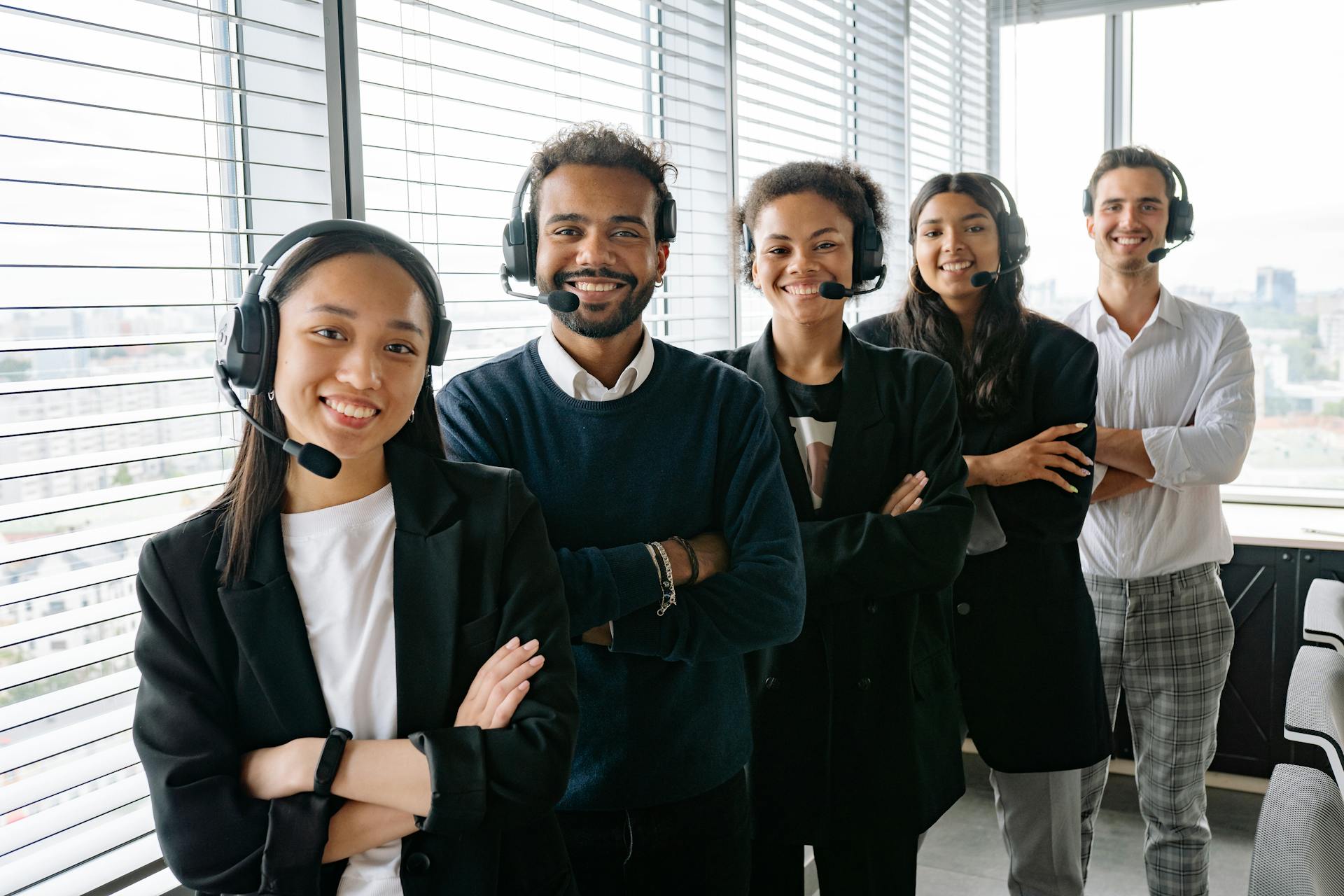 Group of people wearing headsets in an office setting. zaptroni