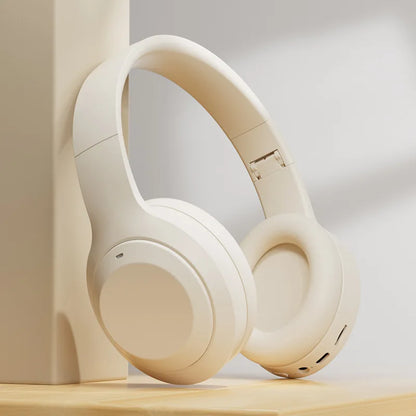Beige headphones on a wooden surface with a neutral background. Bluetooth